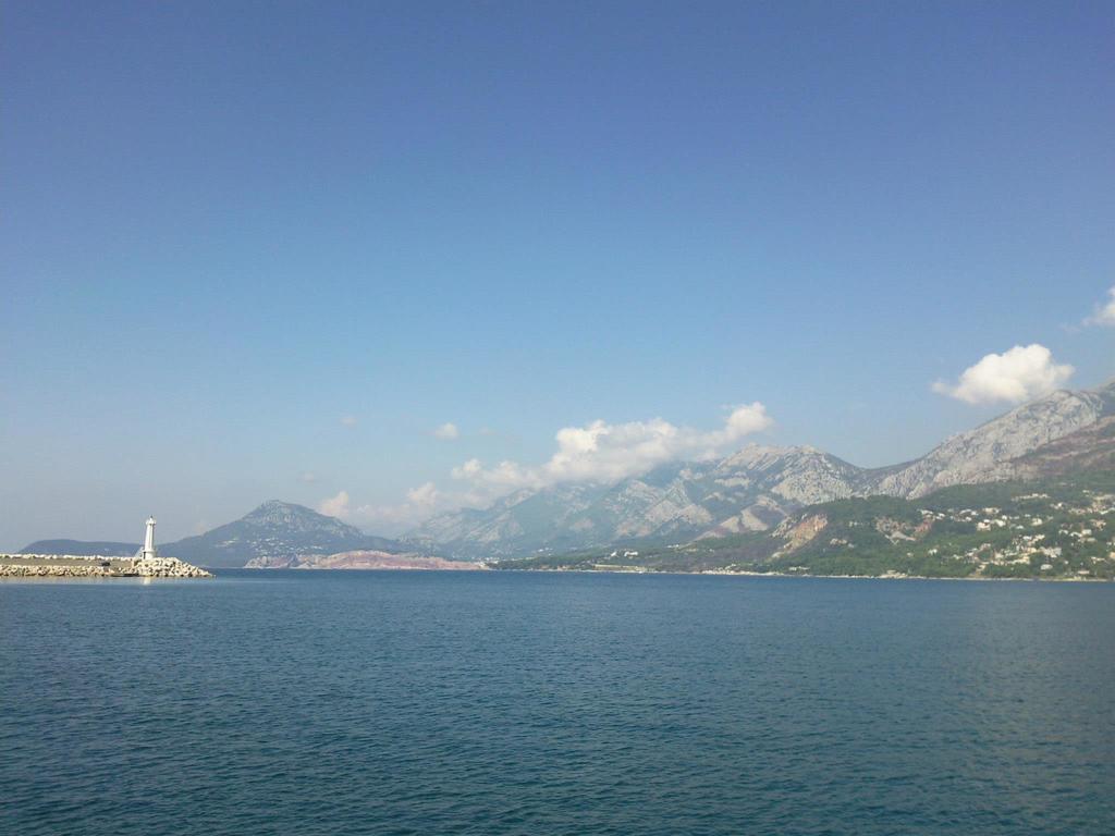 Panoramic view of the sea, mountains, and lighthouse in Šušanj, Bar Riviera, Montenegro. Picturesque seascape.