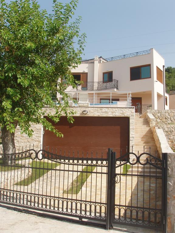 Two-story villa in Šušanj, Bar Riviera, Montenegro: house with garage, terrace, and wrought-iron fence.