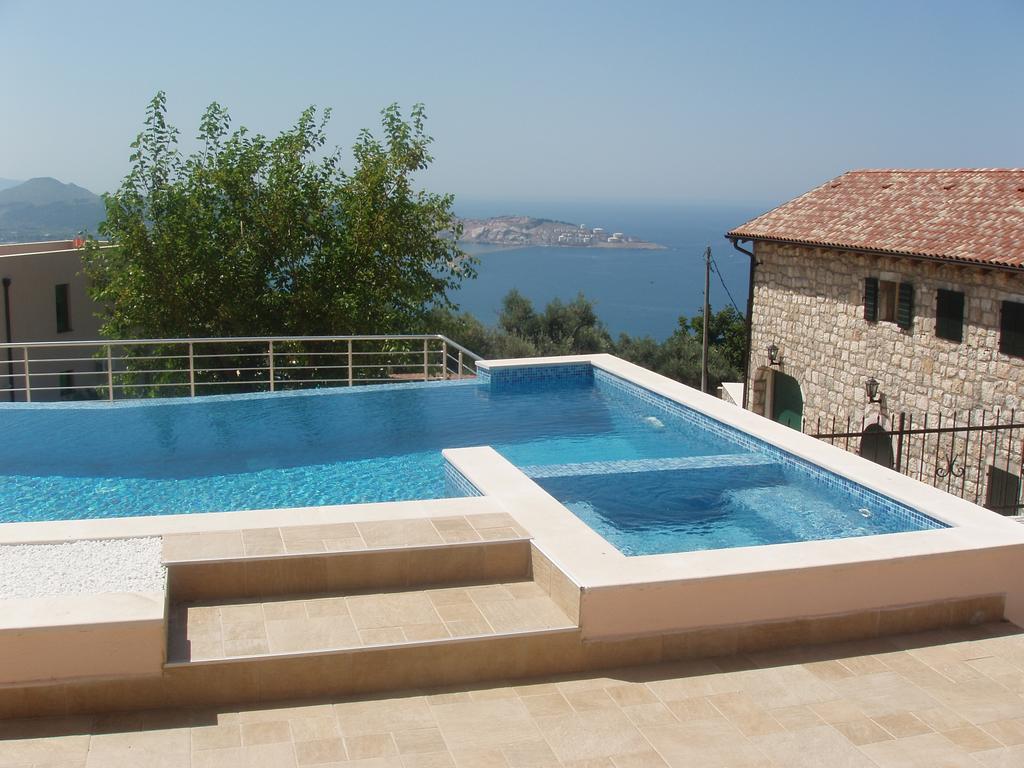 Open-air swimming pool with sea view in a house in Šušanj, Bar Riviera, Montenegro: tiled terrace and panoramic view.