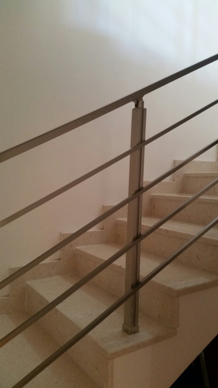 A staircase made of light stone with modern metal railings in an apartment, Budva, Montenegro.