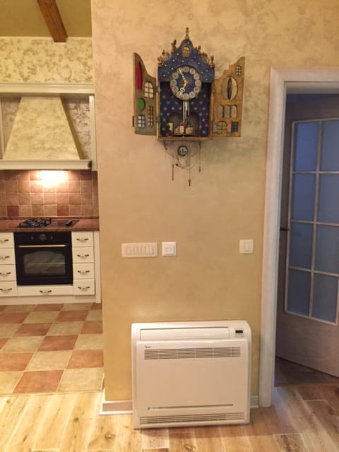 Kitchen interior in a house in Zelenika, Montenegro: decorative wall clock, floor-standing air conditioner, and Provence-style tiles.