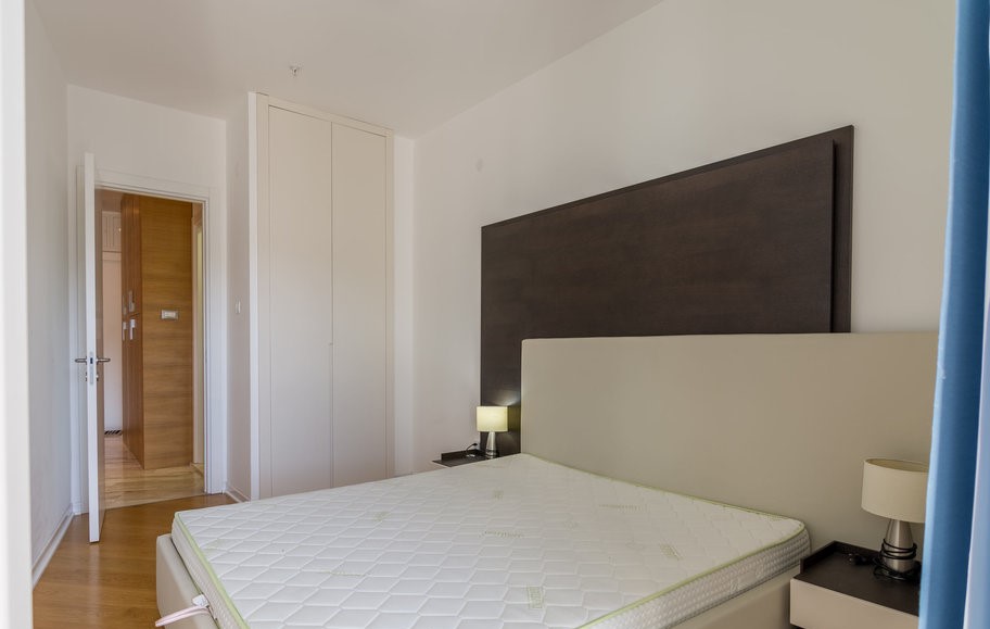 Modern bedroom with a double bed and built-in wardrobe in an apartment, Budva, Montenegro.