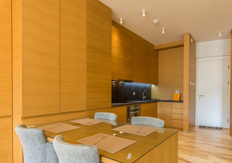 Modern kitchen with wooden finishes and a dining area in an apartment in Budva, Montenegro.