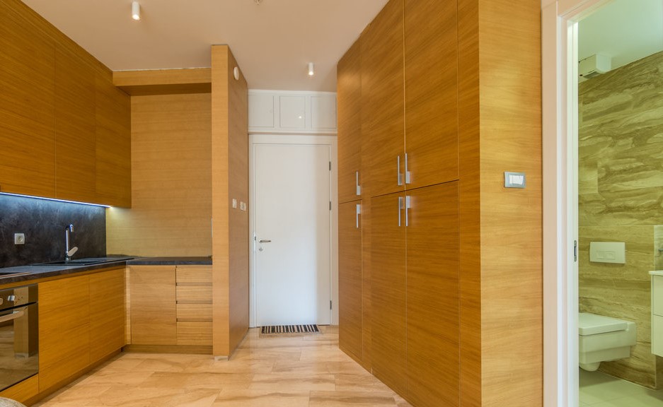 Modern kitchen with wooden facades and built-in cabinet in an apartment, Budva, Montenegro.