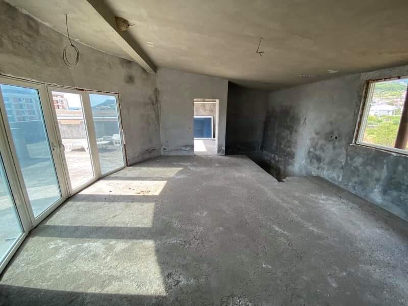 Living room in a house in Shushan, Montenegro, ready for finishing, with panoramic windows and access to the terrace.