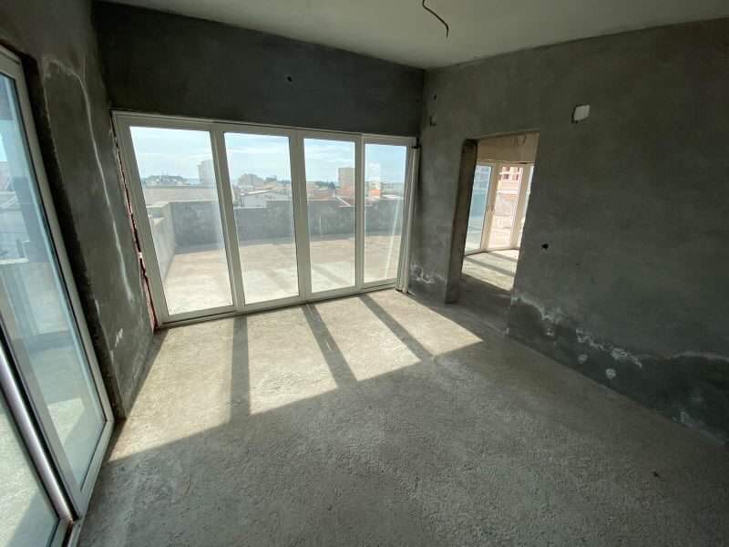 Living room unfinished with panoramic windows and access to the terrace in a building under construction, Shushan, Montenegro.
