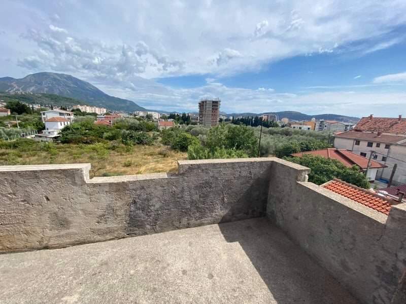 Open terrace of a house in Shushan, Montenegro, with panoramic views of the mountains, olive groves, and urban development.