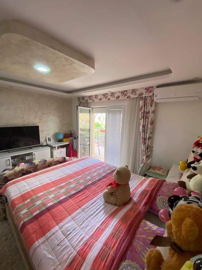 Cozy bedroom with a double bed and access to the balcony in a house, Shushan, Montenegro. Modern interior with a TV.