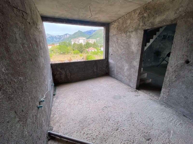 Balcony in a house under construction in Shushan, Montenegro: concrete finish, mountain and city view, open-plan layout.