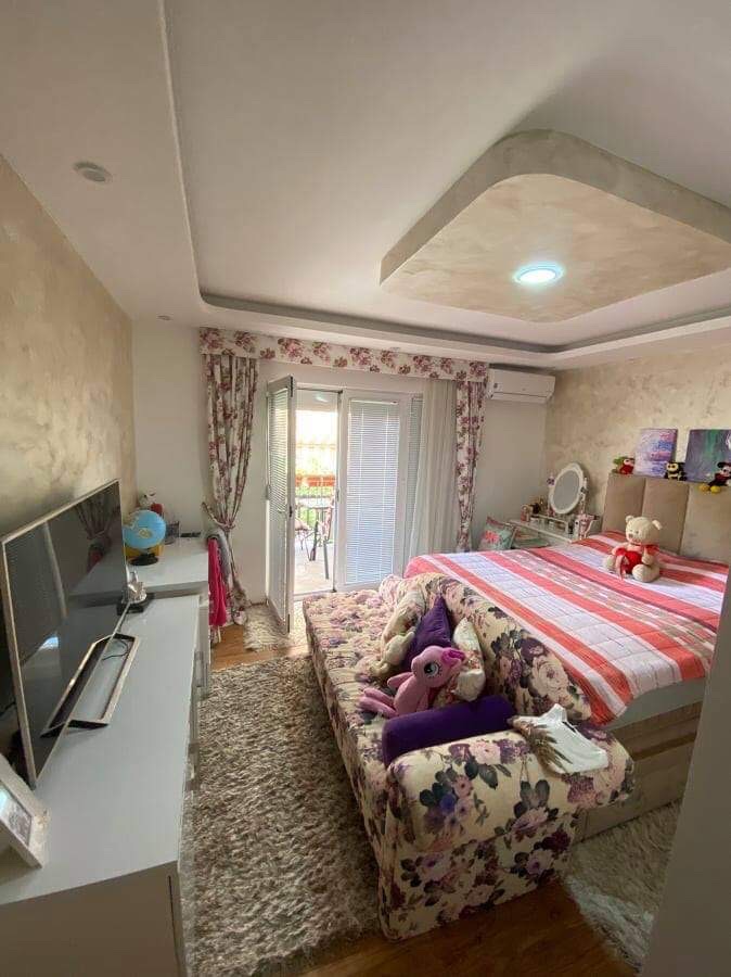 Cozy bedroom with a double bed and access to the balcony in a house, Shushan, Montenegro. Bright interior with furniture.