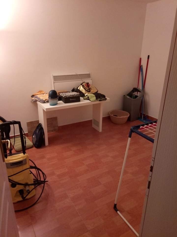 Utility room in a house in Šušanj, Montenegro: white furniture, tiled floor, and cleaning supplies.