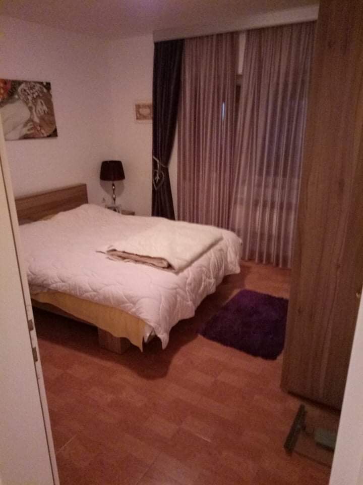 Cozy bedroom with a double bed and wardrobe in a house, Shushan, Montenegro. Bright interior with tiled flooring.