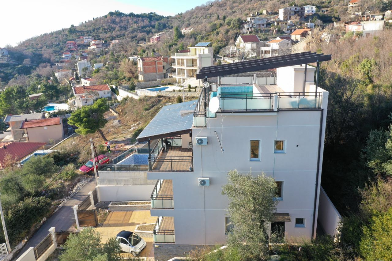 Modern villa in Shushan, Montenegro: a house with terraces, a rooftop pool, and views of the mountains and the sea.