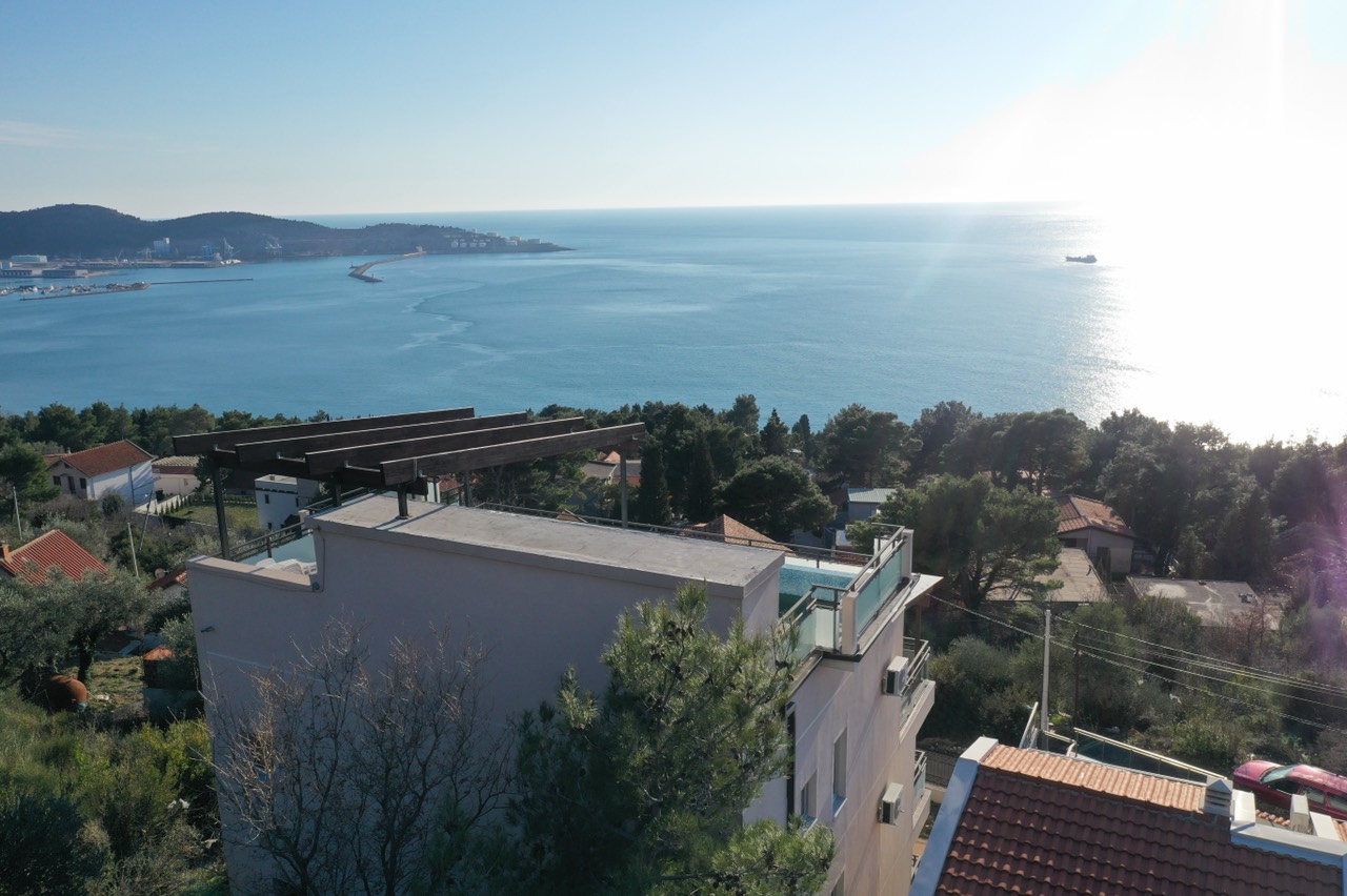 View of a house with a rooftop pool and panoramic sea view in Šušanj, Montenegro. Modern architecture and terrace.