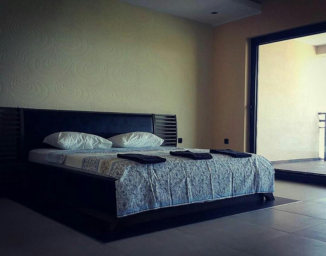 Bedroom with a double bed and access to the terrace in a house, Shushan, Montenegro. Modern interior.