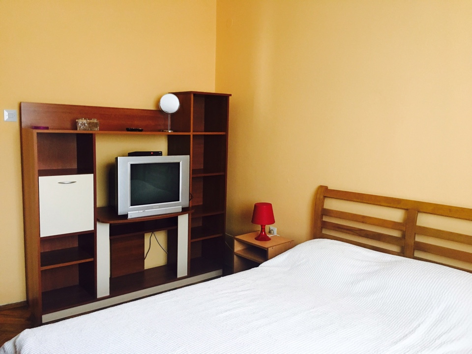 Bedroom in a house in Shushan, Montenegro: double bed, wooden furniture, TV, and a red table lamp.