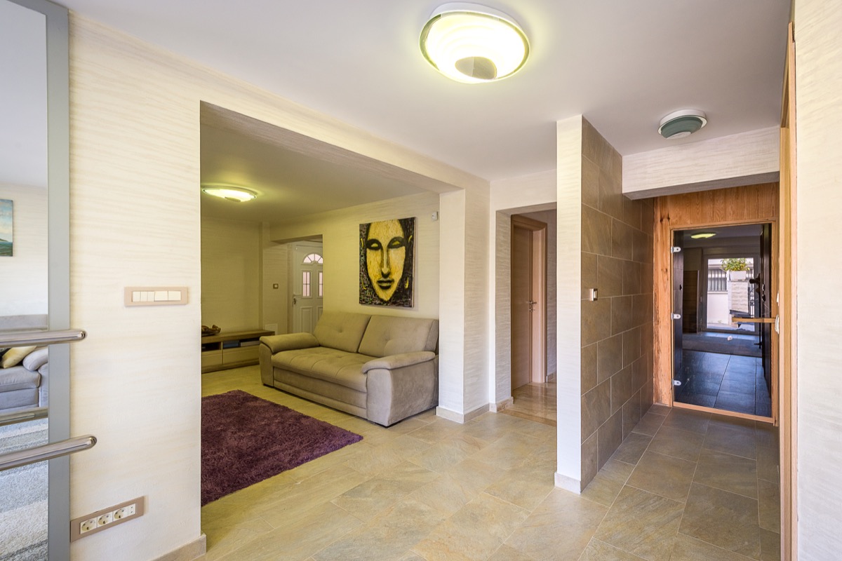 Living room with a sofa and sauna in a modern villa in Krašići, Montenegro: stylish interior with tile flooring and decor.