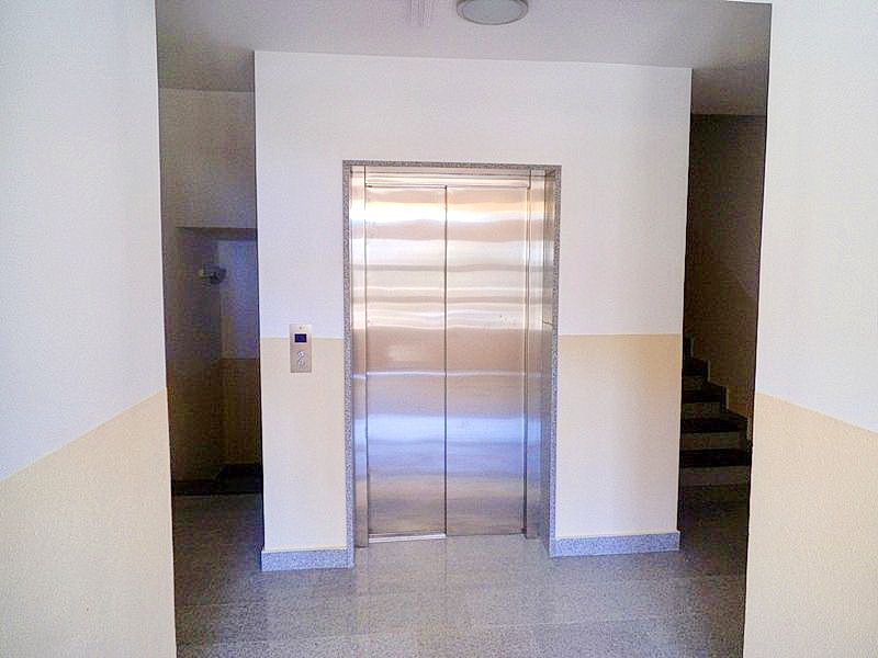 Modern elevator with metal doors in the hotel lobby in Bečići, Montenegro, with wall finishes and a stone floor.