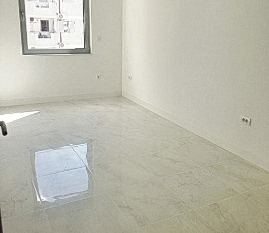 Bright living room with porcelain stoneware finishes in a new residential complex in Budva, Montenegro.