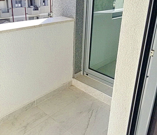 Bright balcony with panoramic glazing in a residential complex, Budva, Montenegro: modern finishes and tile.