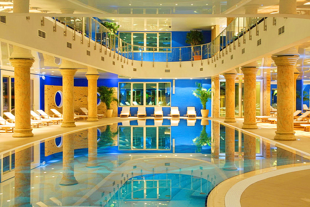 Indoor swimming pool with columns and lounge area in a residential complex in Bečići, Montenegro: modern design and interior.