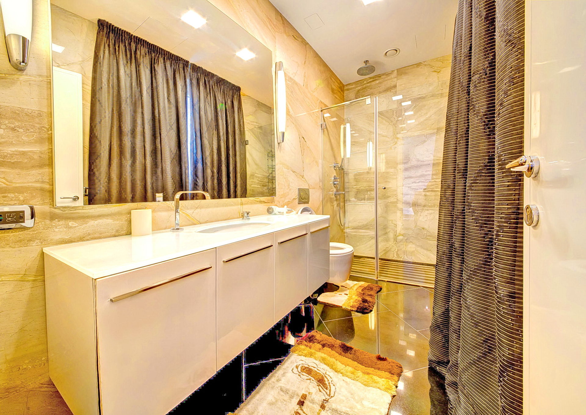 Modern bathroom with a shower cabin and beige marble finishes in an apartment, Bečići, Montenegro.