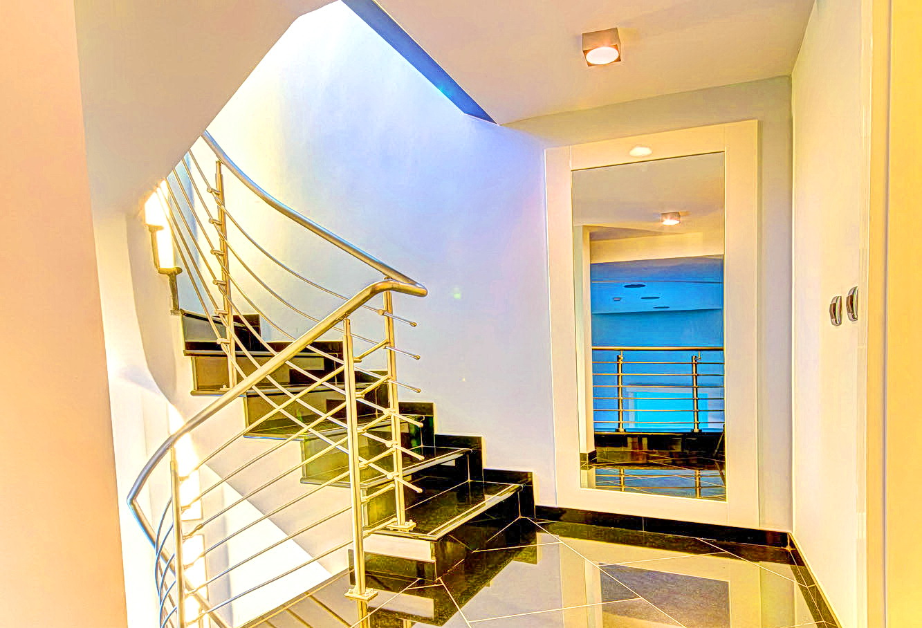 Modern spiral staircase with metal railings and black tiles in an apartment, Bečići, Montenegro.