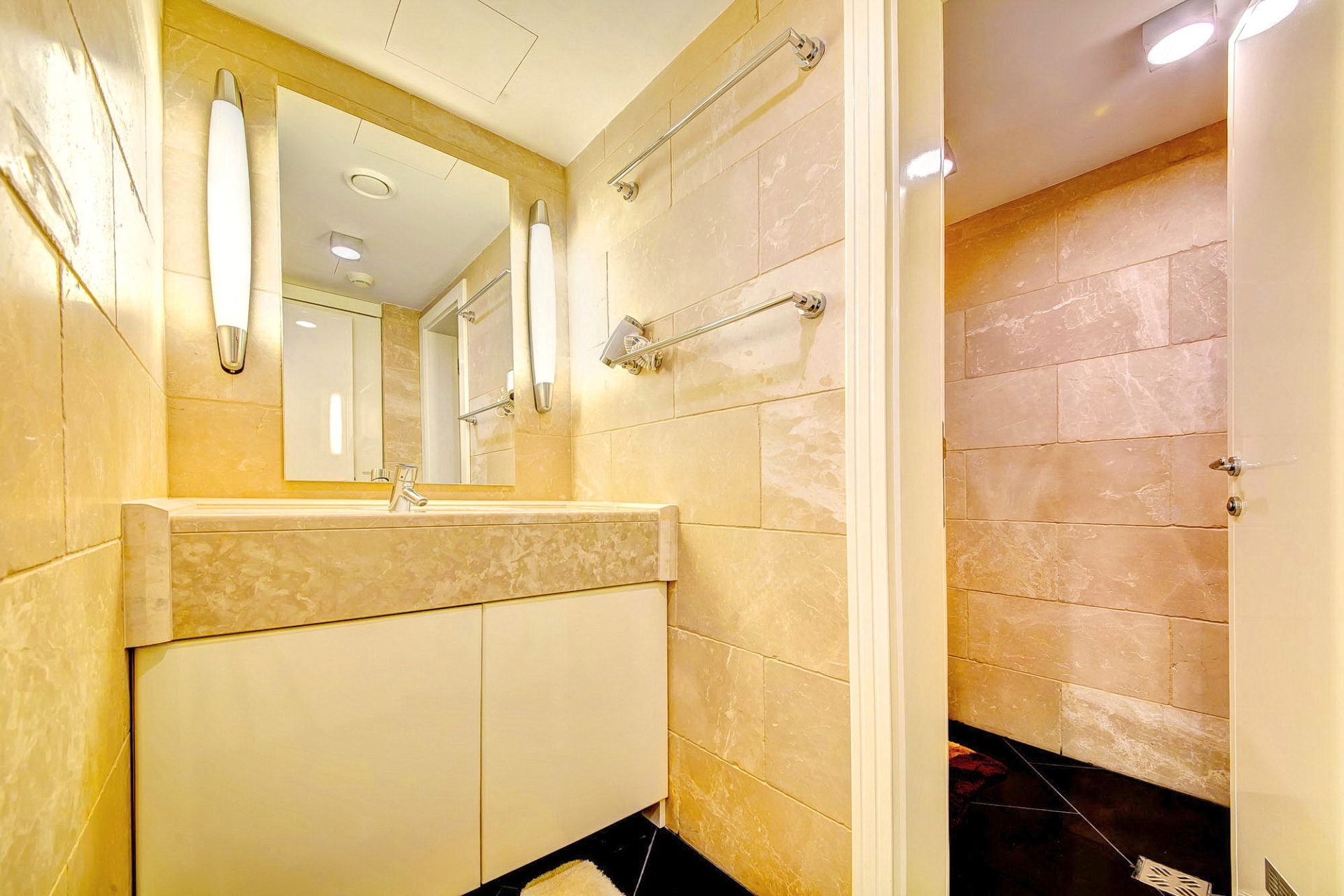 Modern bathroom with beige tiles and a shower cabin in an apartment in Bečići, Montenegro.