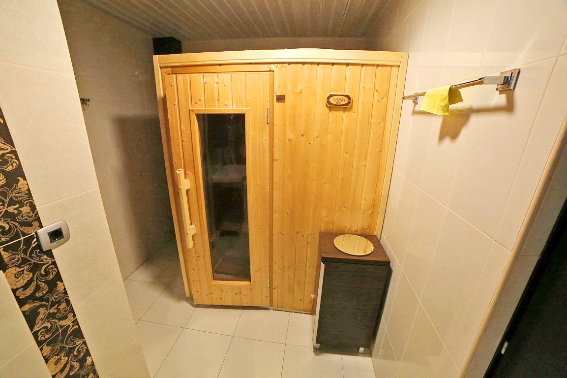 Bathroom with a wooden sauna in a villa in Budva, Montenegro: modern tile finishes and stylish furniture.