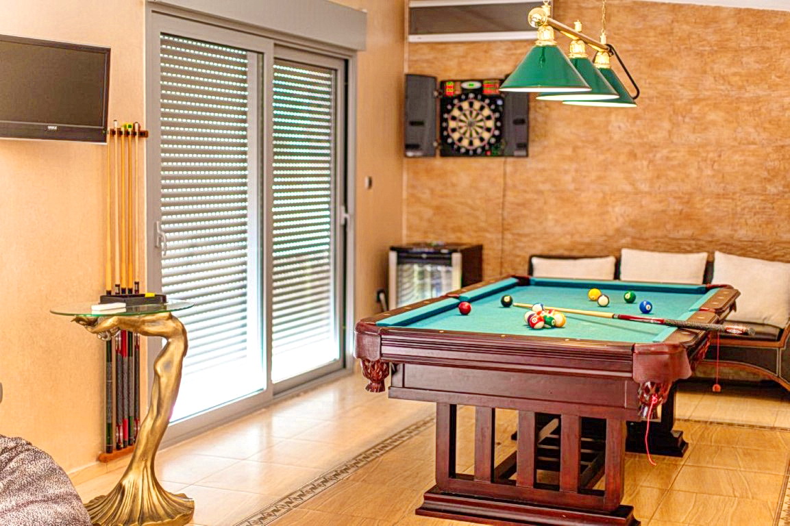 Game room with a billiard table and darts at a villa in Budva, Montenegro: stylish interior with a lounge area.