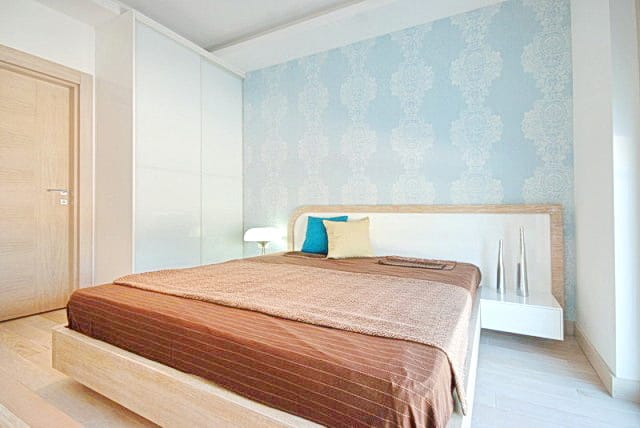 Bright bedroom with a double bed and built-in wardrobe in a residential complex in Morinj, Montenegro: modern interior and design.
