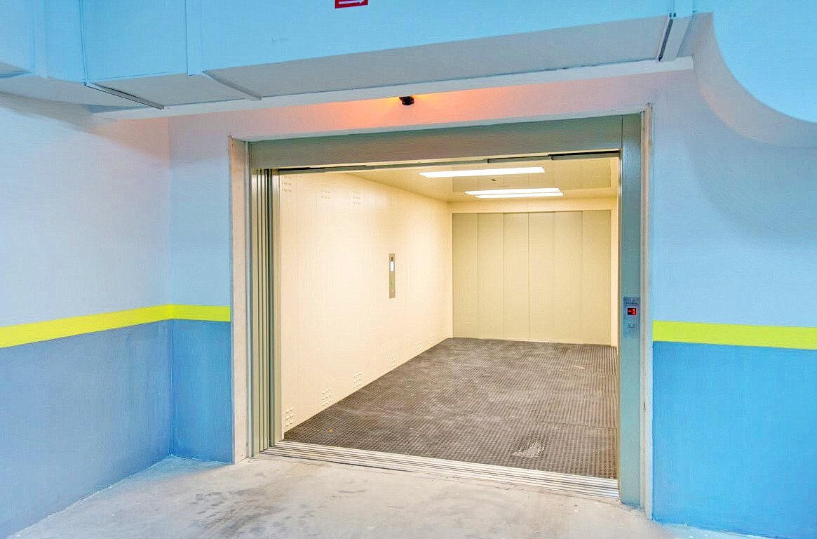 Freight elevator in the underground parking garage of a residential complex in Rafailovići, Montenegro: modern cabin with lighting.