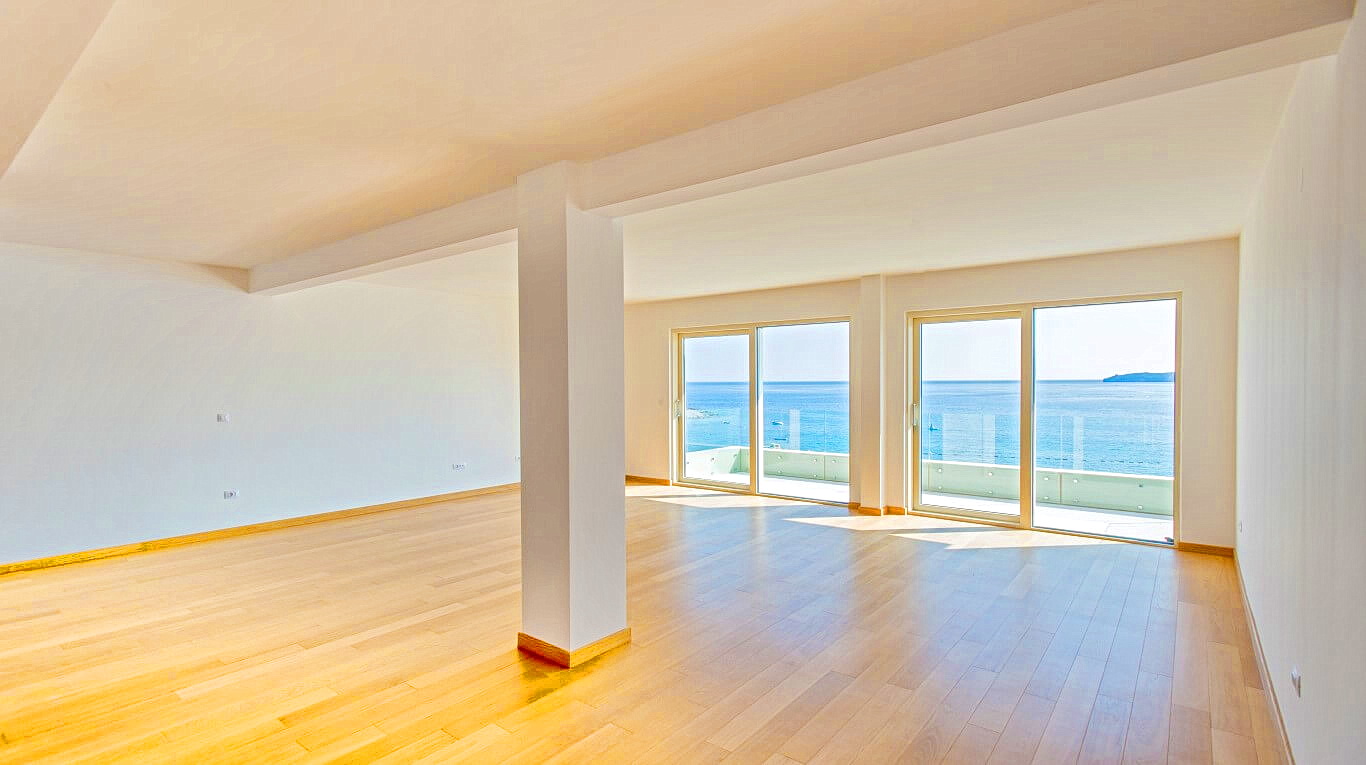 Spacious living room with panoramic sea view in an apartment, Rafailovići, Montenegro: bright interior and parquet flooring.