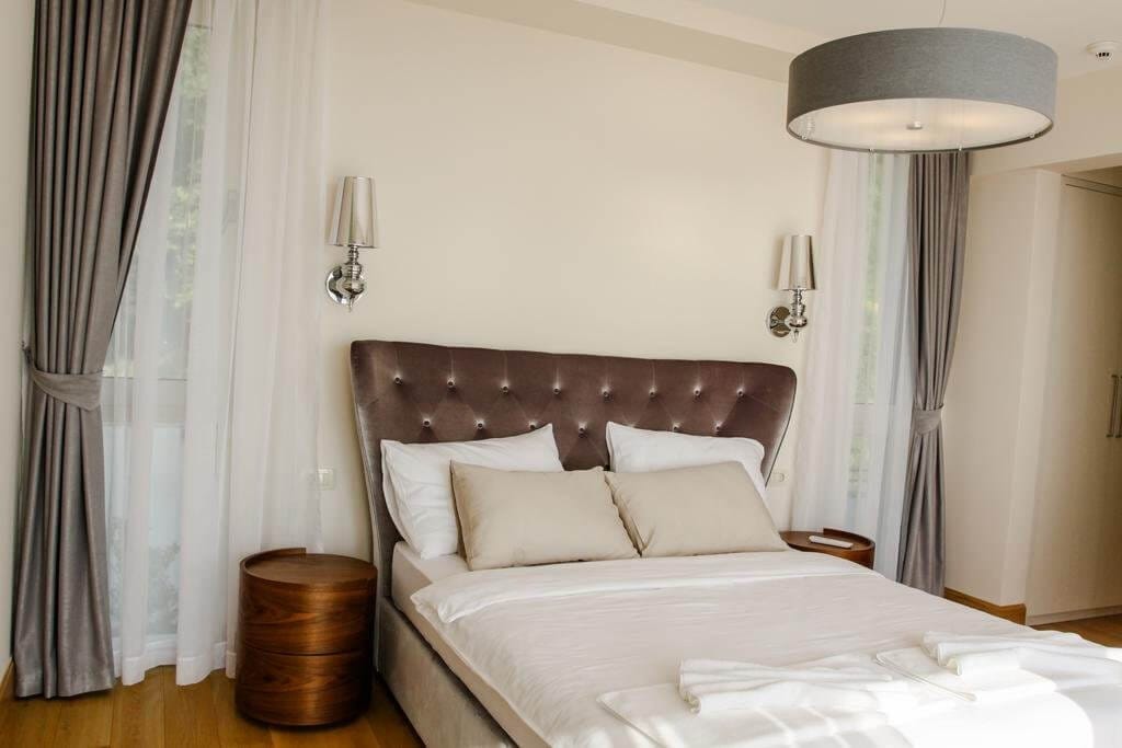 Modern bedroom with a double bed in a villa in Blizikuće, Montenegro: stylish furniture and a cozy interior.