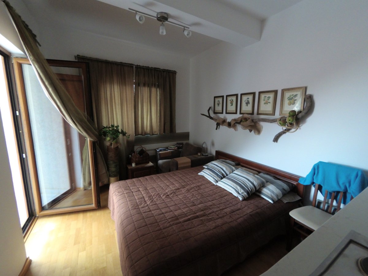 Cozy bedroom with a double bed in an apartment in Budva, Montenegro: bright interior, access to the balcony, and decor.