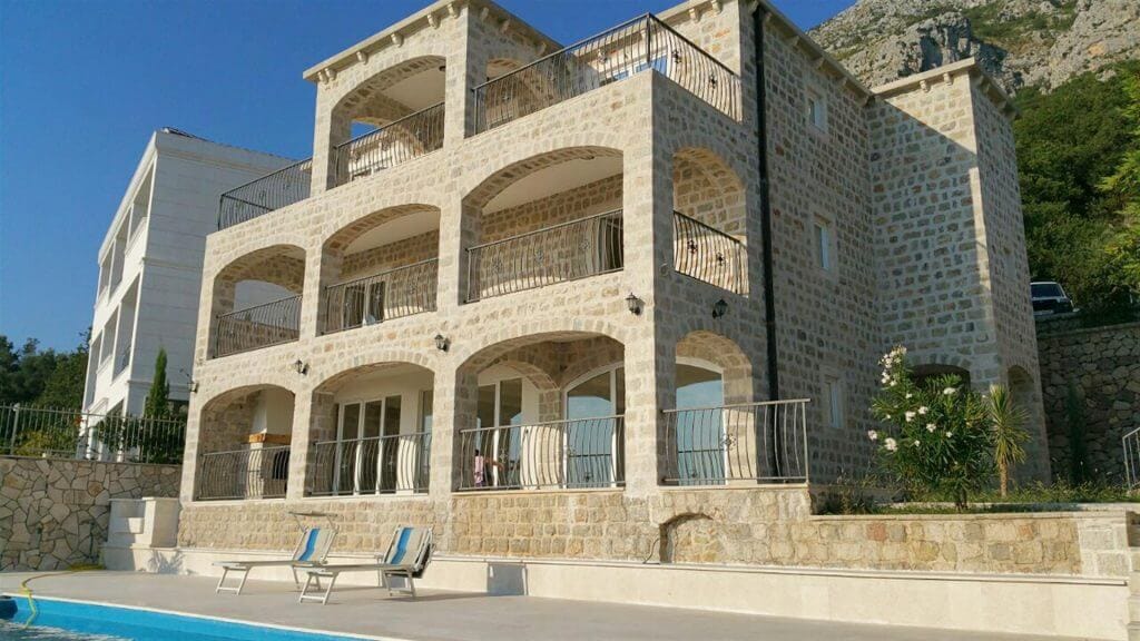 Three-story stone villa with a pool and terraces in Drobni Pijesak, Montenegro. Natural stone facade.
