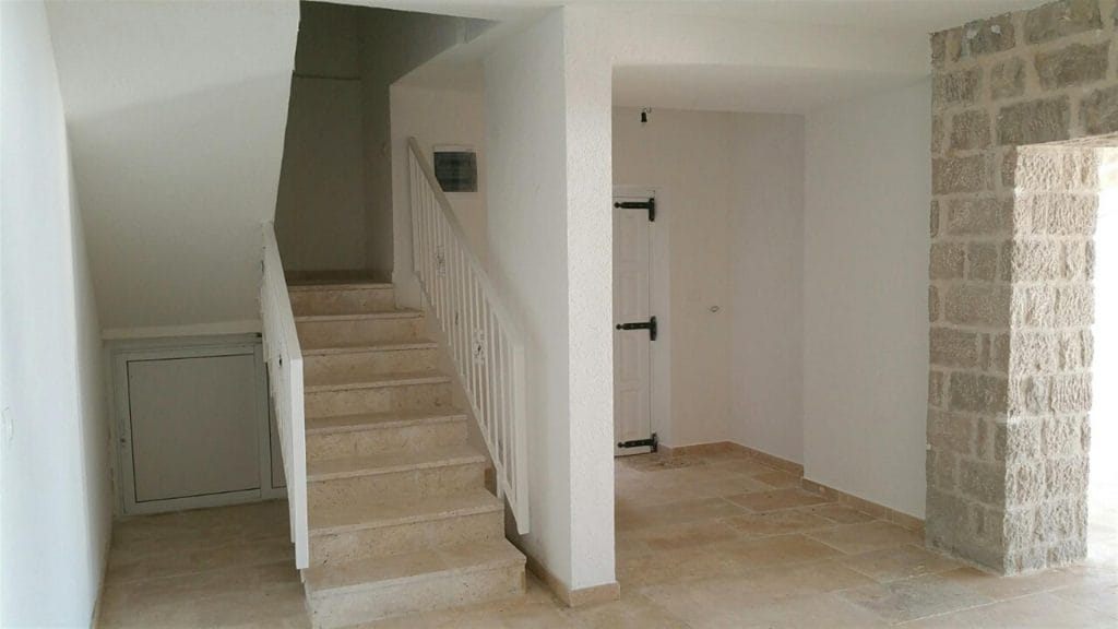 Villa interior in Drobni Pijesak, Montenegro: stone masonry, marble staircase, and light room finishes.