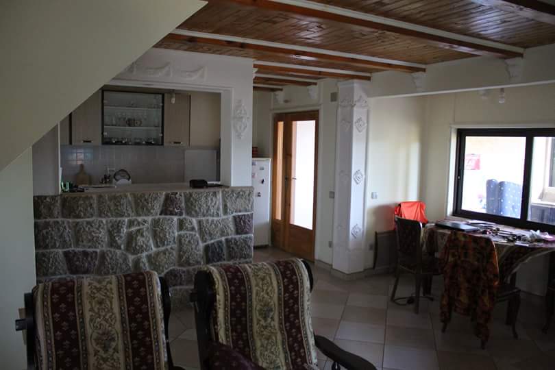 Living room with a stone bar counter and wooden ceiling in a house for sale, Sutomore, Montenegro.