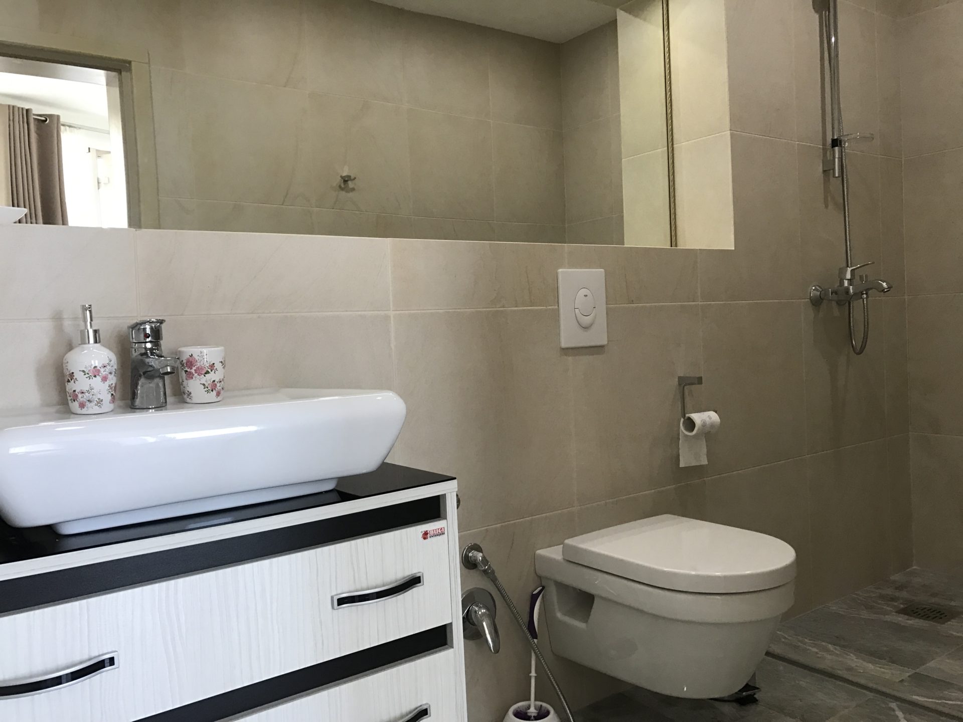 Modern bathroom with a shower cabin in a villa in Uteha, Montenegro: white sanitary ware and beige tiles.