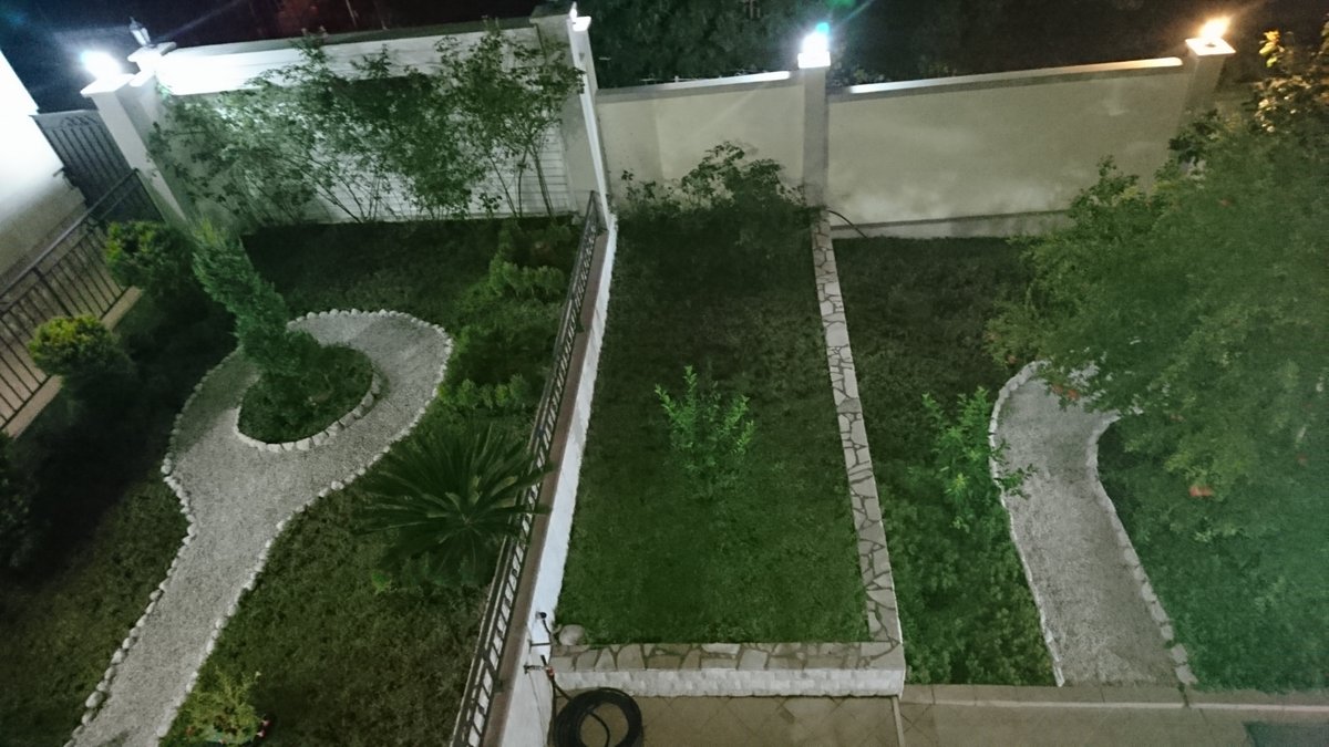 Well-maintained landscaped garden with lighting at a villa in Utjeha, Montenegro: gravel paths and a green lawn.