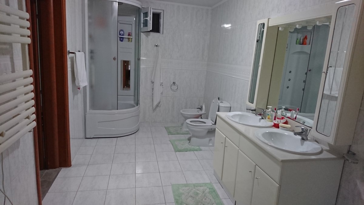 Spacious bathroom in a villa in Utjeha, Montenegro: shower cabin, bidet, toilet, and vanity with double sink.