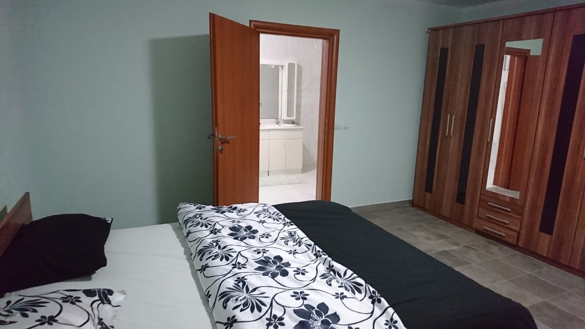 Bedroom with a double bed, wardrobe, and access to the bathroom in a villa in Utjeha, Montenegro.
