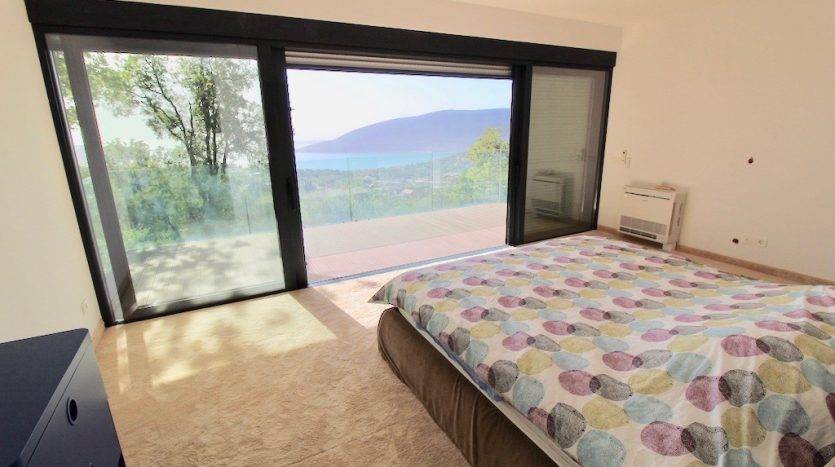 Bedroom in a villa in Herceg Novi, Montenegro: panoramic window with sea view, terrace, and modern interior.