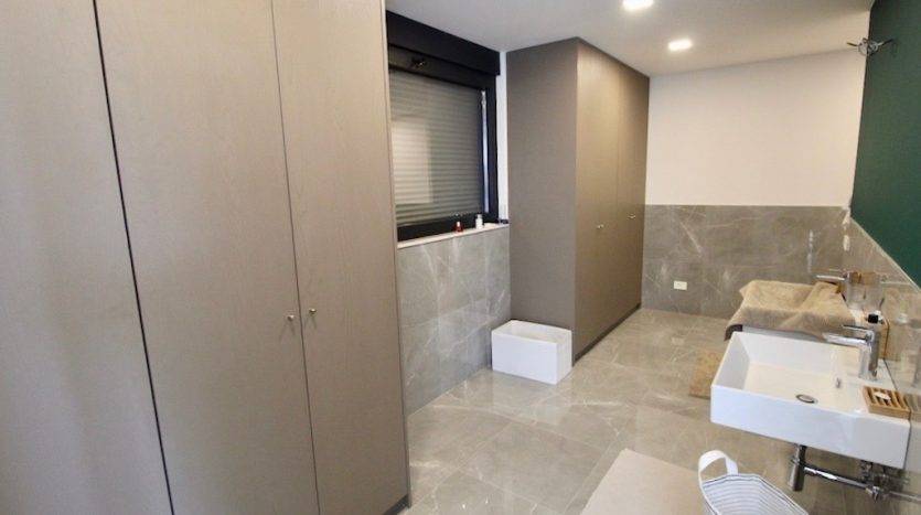 Modern bathroom with gray cabinets and marble-look tiles in a villa in Herceg Novi, Montenegro.