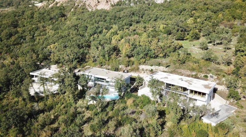 Modern villas with pools surrounded by forest, Herceg Novi, Montenegro: aerial view of luxury real estate.
