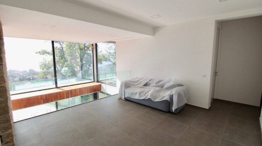 Living room in a villa in Herceg Novi, Montenegro: panoramic windows, glass railings, and a view of nature.