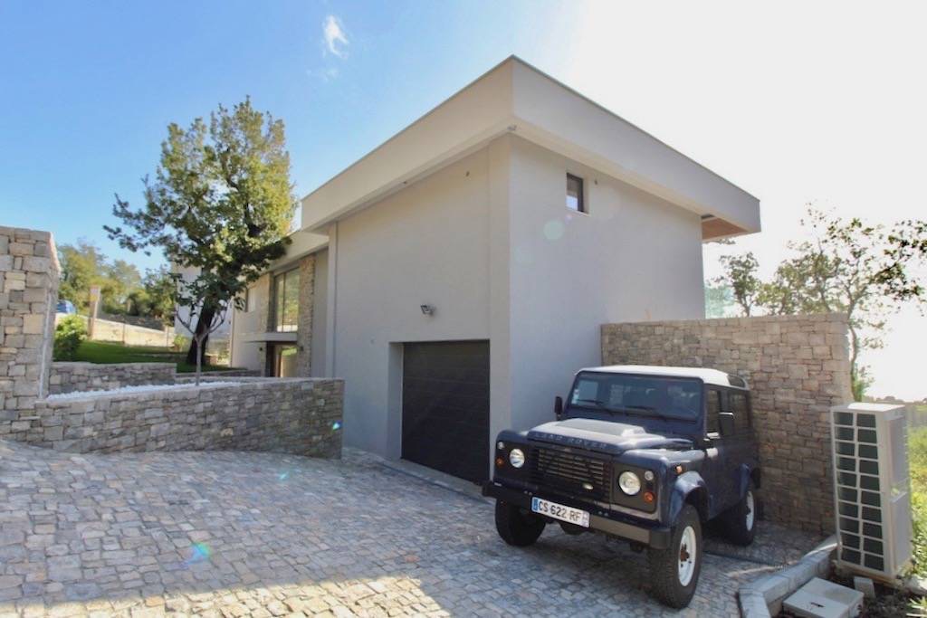 Modern villa in Herceg Novi, Montenegro: stone-clad facade, garage, and paved parking area.