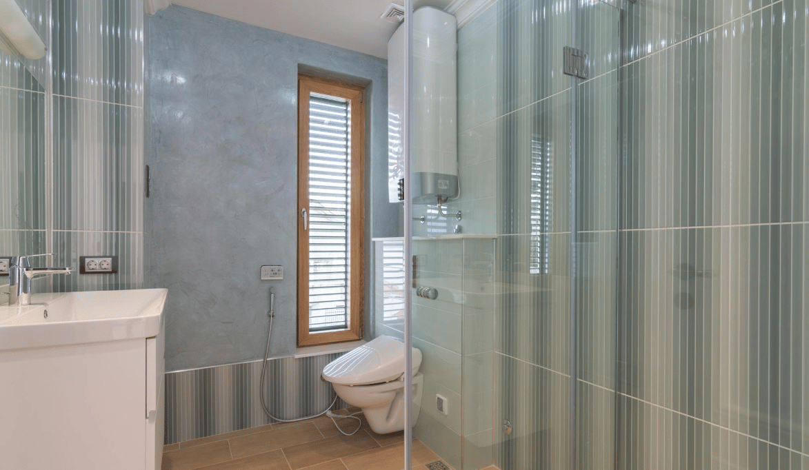 Modern bathroom with a shower cabin and window in a villa in Bijela, Montenegro: stylish finishes and fixtures.