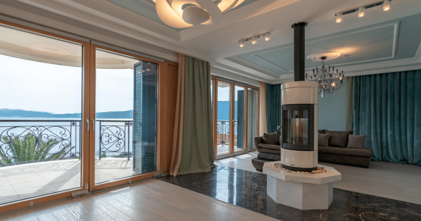 Living room with a fireplace and panoramic sea view in an exclusive villa, Bijela, Montenegro: stylish interior and terrace.