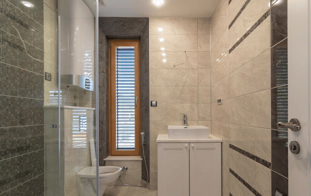 Modern bathroom with a shower cabin and a window in a villa in Bijela, Montenegro: stylish tile finish.